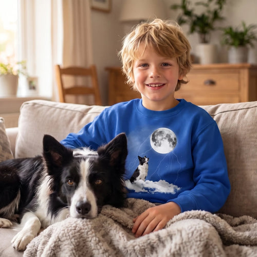 Boy on the sofa with his border collie in a royal blue kids' custom pet cloudy night sweatshirt