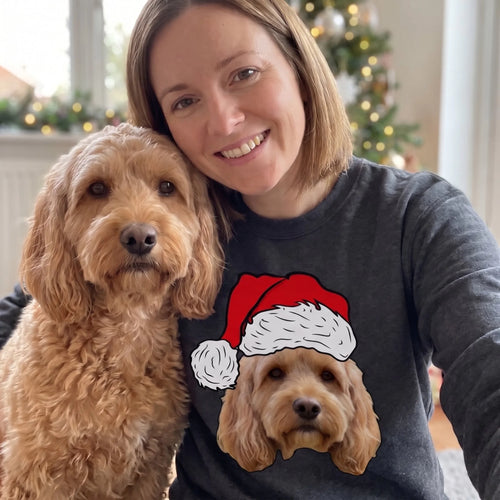 Woman in a charcoal novelty pet face Christmas sweatshirt taking a selfie with her cockapoo