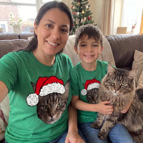 Mum and son in matching green novelty pet face Christmas t-shirts with their Maine Coon cat