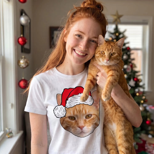 Woman holding her ginger cat beside her white novelty pet face Christmas t-shirt